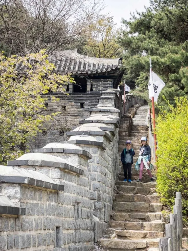 Two kids enjoy a family walk around the Suwon Hwaseong Fortress - a UNESCO world heritage site near Seoul, South Korea.
