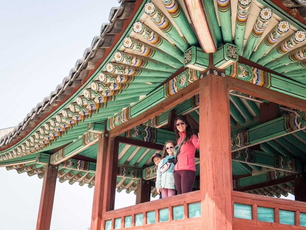 a family stands in a colorful building along the walls at the UNESCO fortress in Suwon, South Korea.