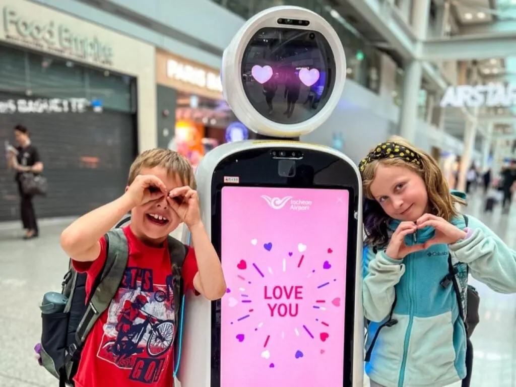 two kids on a family trip to Seoul are greeted by a friendly robot at the Incheon Airport.