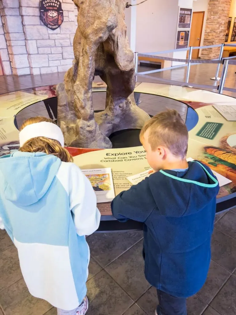 two kids work on their Junior Ranger workbooks at the Carlsbad Caverns Visitor Center.