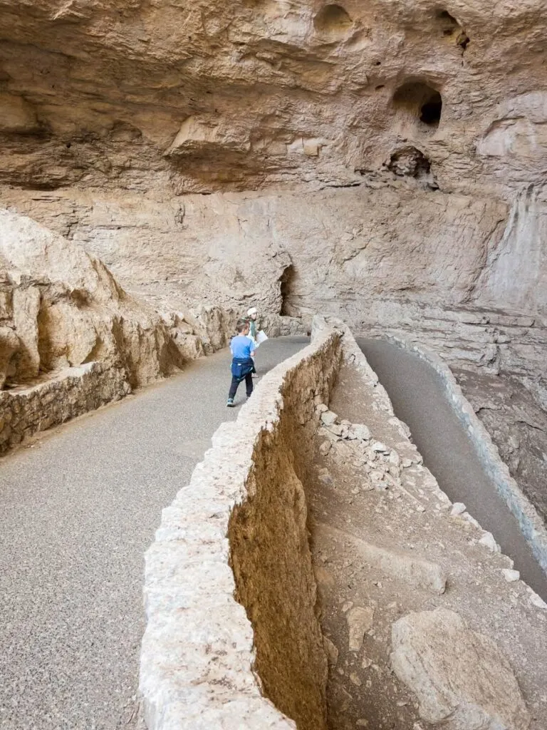 a young boy walks down the ramp into the cave entrance.