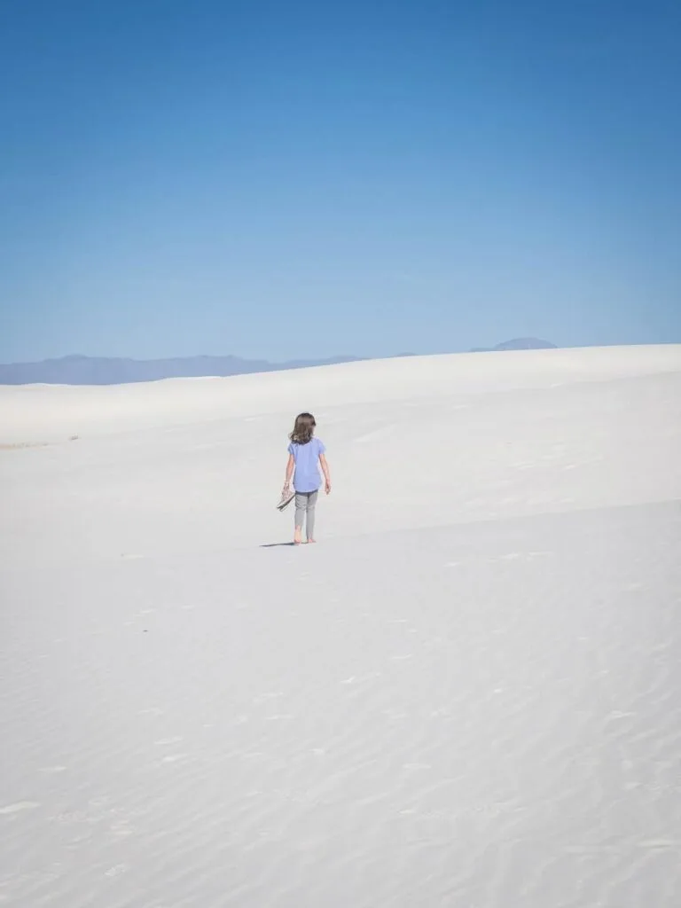 a young girl hikes in white sands, new mexico.