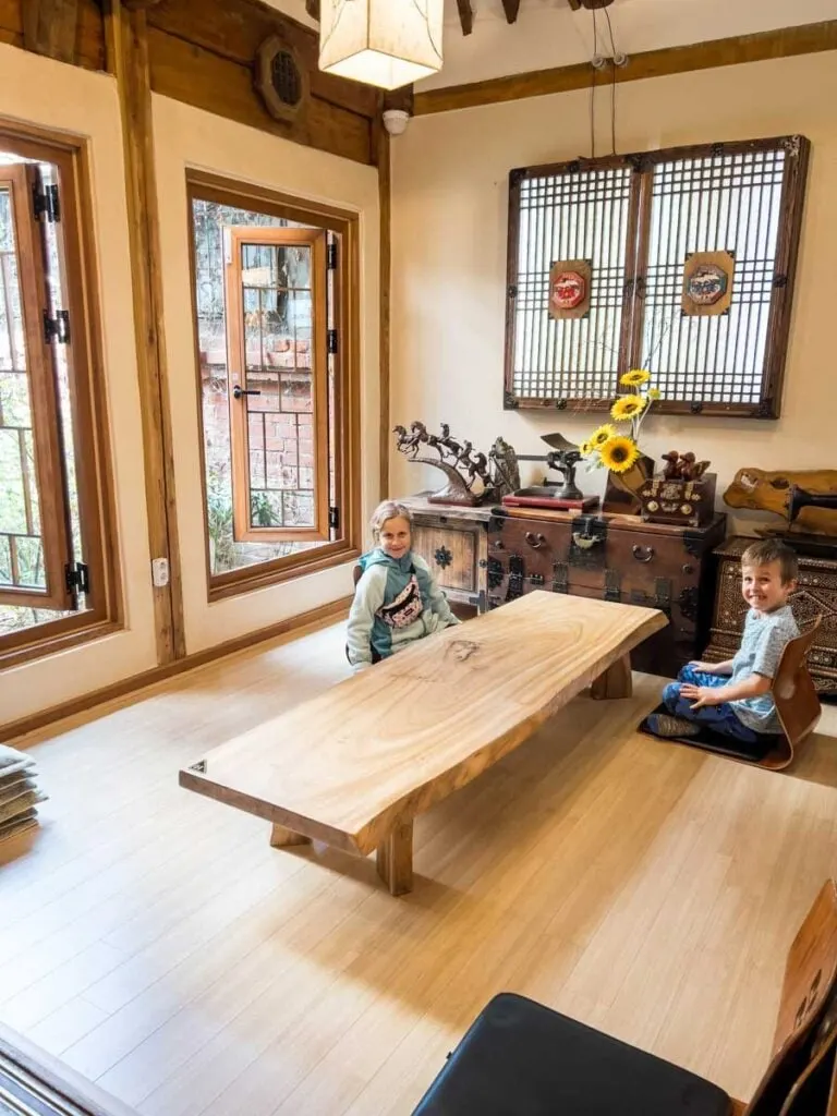 two kids sit at a low table at a Ikseondong tea house during a Seoul food tour on a family vacation to South Korea.