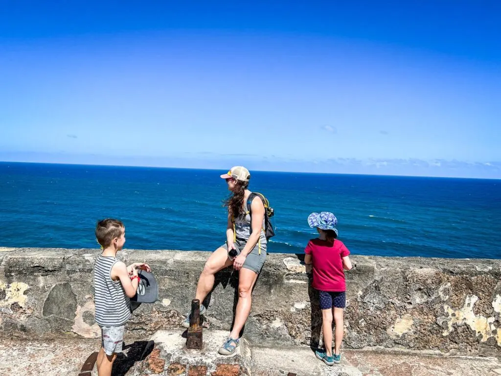 a family enjoys the vistas of the Caribbean Sea from one of the historic forts in San Juan, Puerto Rico.