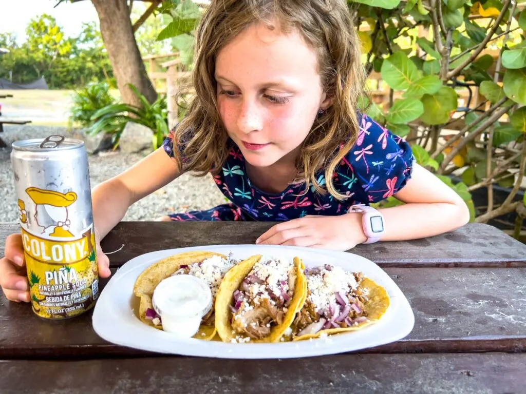 a girl eats a meal of delicious tacos at a food truck just outside Isabel Segunda.