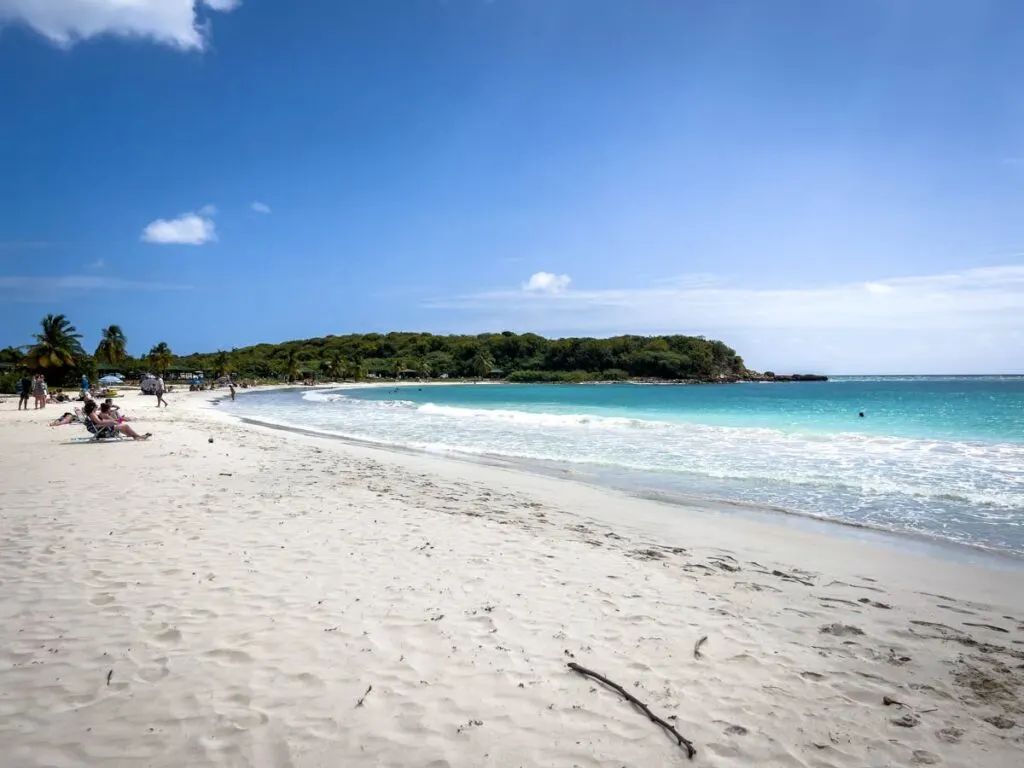 sun lovers flock to Playa Caracas beach on Vieques, Puerto Rico to enjoy the soft white sand and warm, turquoise waters.