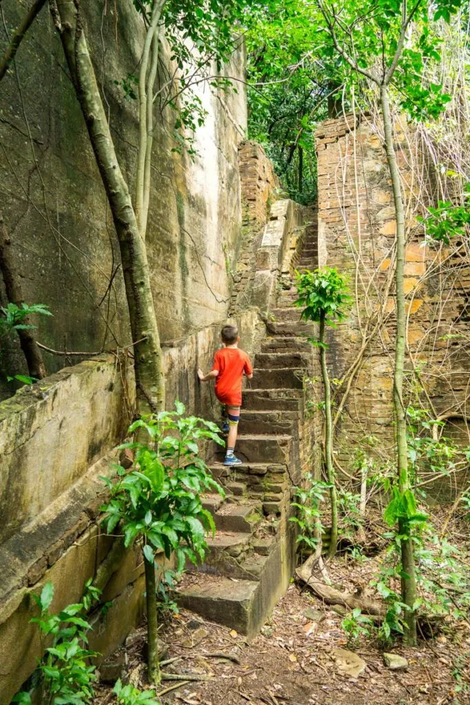 a boy climbs a set of stairs on the Vieques sugar mills ruins hike.