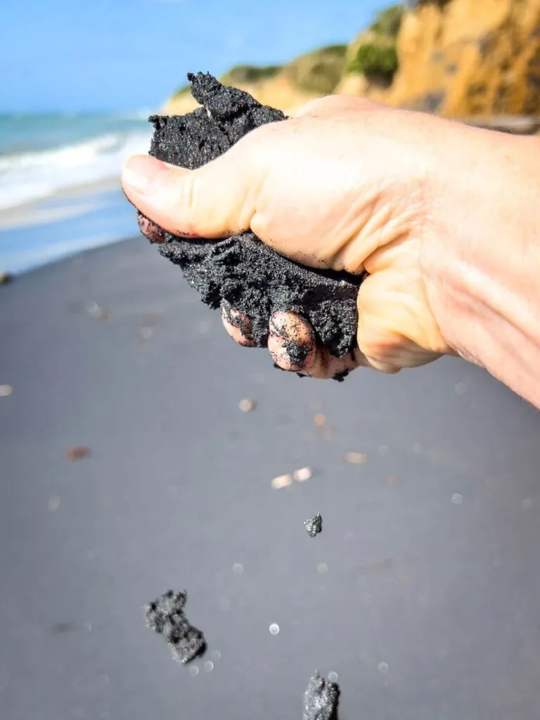 a close-up shows how black the sand is at Playa Negra beach in Vieques, Puerto Rico.