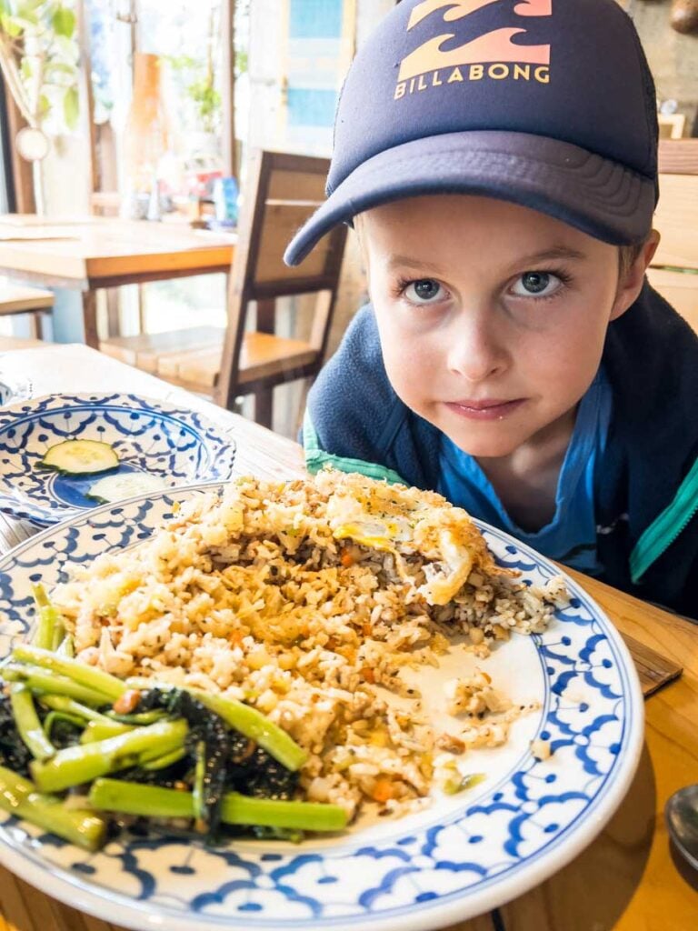 a picky eater looks unimpressed with his Thai food while on a family trip to Korea.
