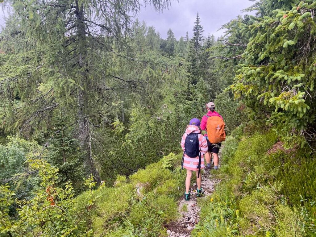 a family hikes to a julian alps mountain hut in the rain.