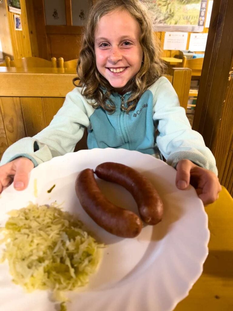 a hungry child is happy for her mountain hut meal in Slovenia.