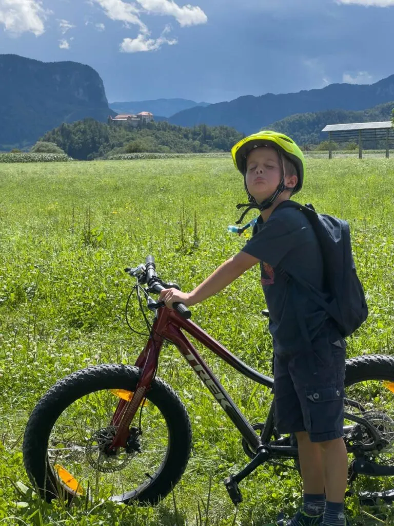 a boy makes a face while standing next to his rental bike near Lake Bled, Slovenia.