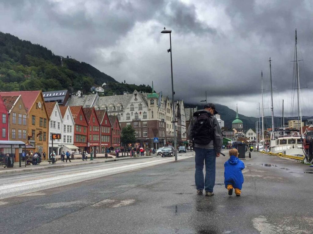 Dan Brewer, owner of FamilyCanTravel.com, walks through Bryggen on a rainy day on a family trip to Bergen with kids.