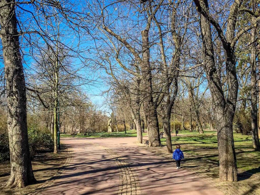 a 2-year old boy enjoys an easy walk in Prague with his family in Letna Park.