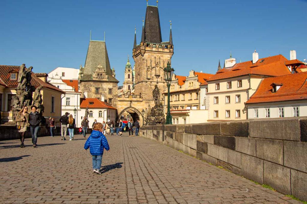 a young boy on a family trip to Prague, crosses the Old Charles Bridge.