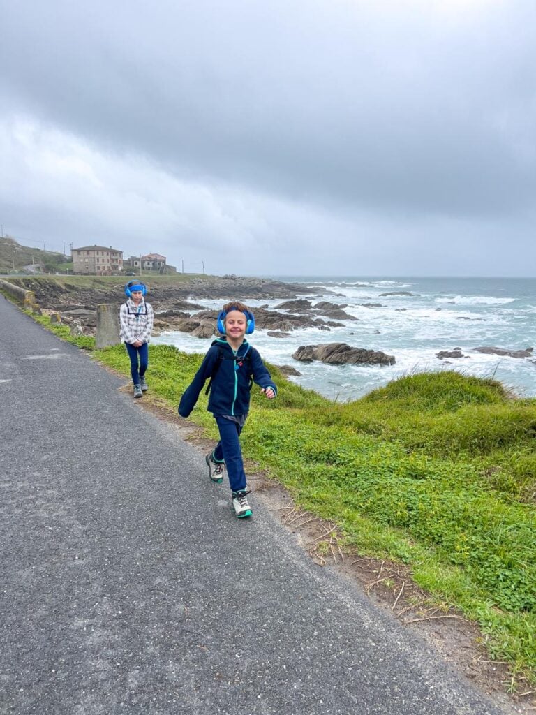 A happy 8-year old walks the Portuguese Camino Route next to the Atlantic Ocean.