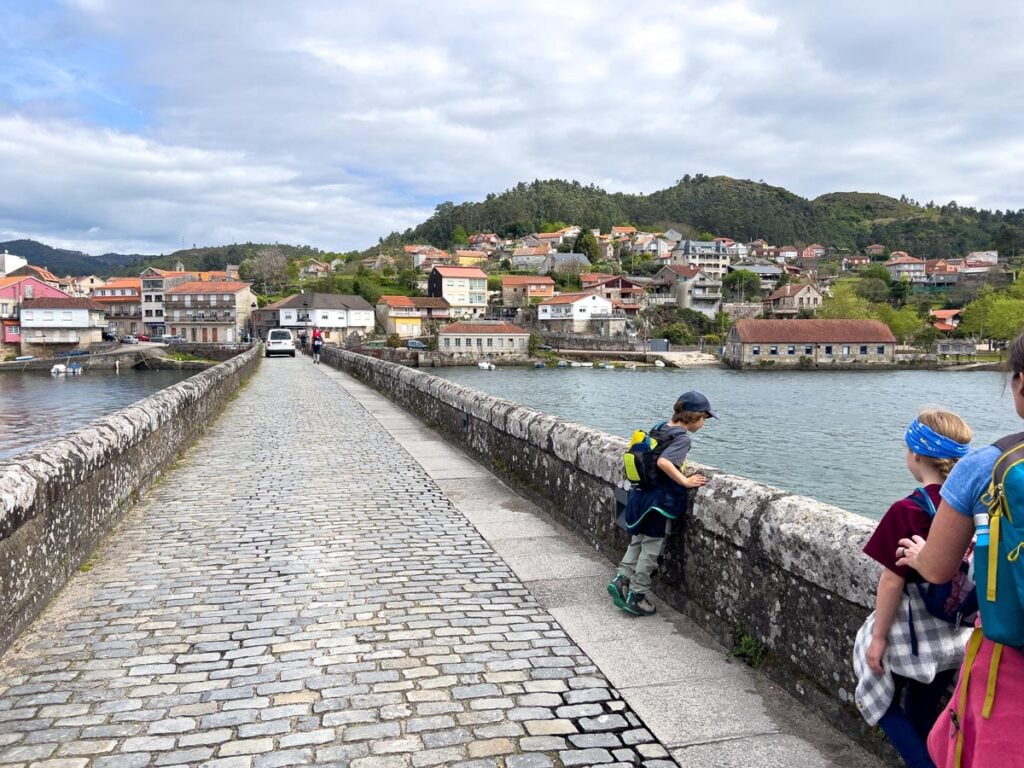 The FamilyCanTravel.com family crosses a bridge over the Rio de Vigo, while hiking the third leg of the Portuguese Camino Route.