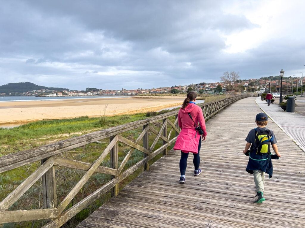 Celine Brewer, from the Family Can Travel blog, walks along a beach boardwalk with her son on the Portuguese Coastal CAmino Trail.