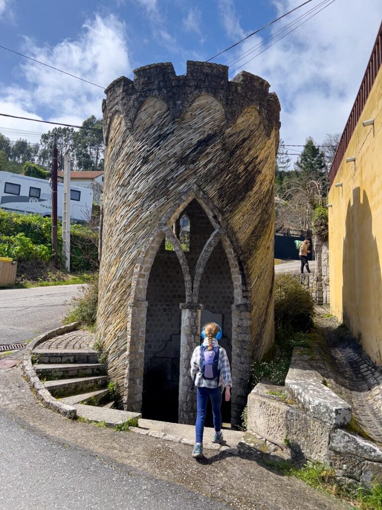 A 10-year old girl pauses her family Camino hike to investigate an interesting old building in Baiona, Spain.