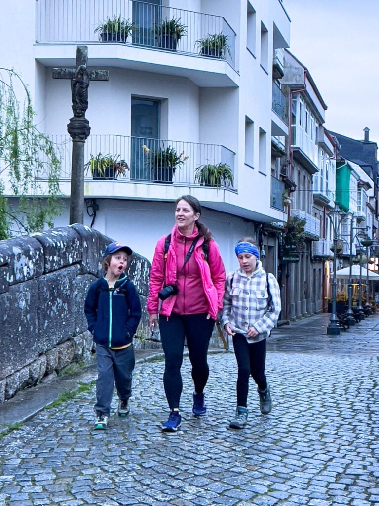 Celine Brewer, a travel expert from the FamilyCanTravel blog, walks through Caldas de Reis with her kids on the fifth day of their family walking tour on the Portuguese Coastal Camino Trail.