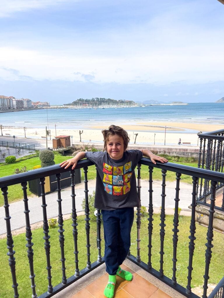 An 8-year old boy relaxes on the balcony of his beachfront hotel at the end of a long day hiking the Portuguese Coastal Camino Trail with his family.