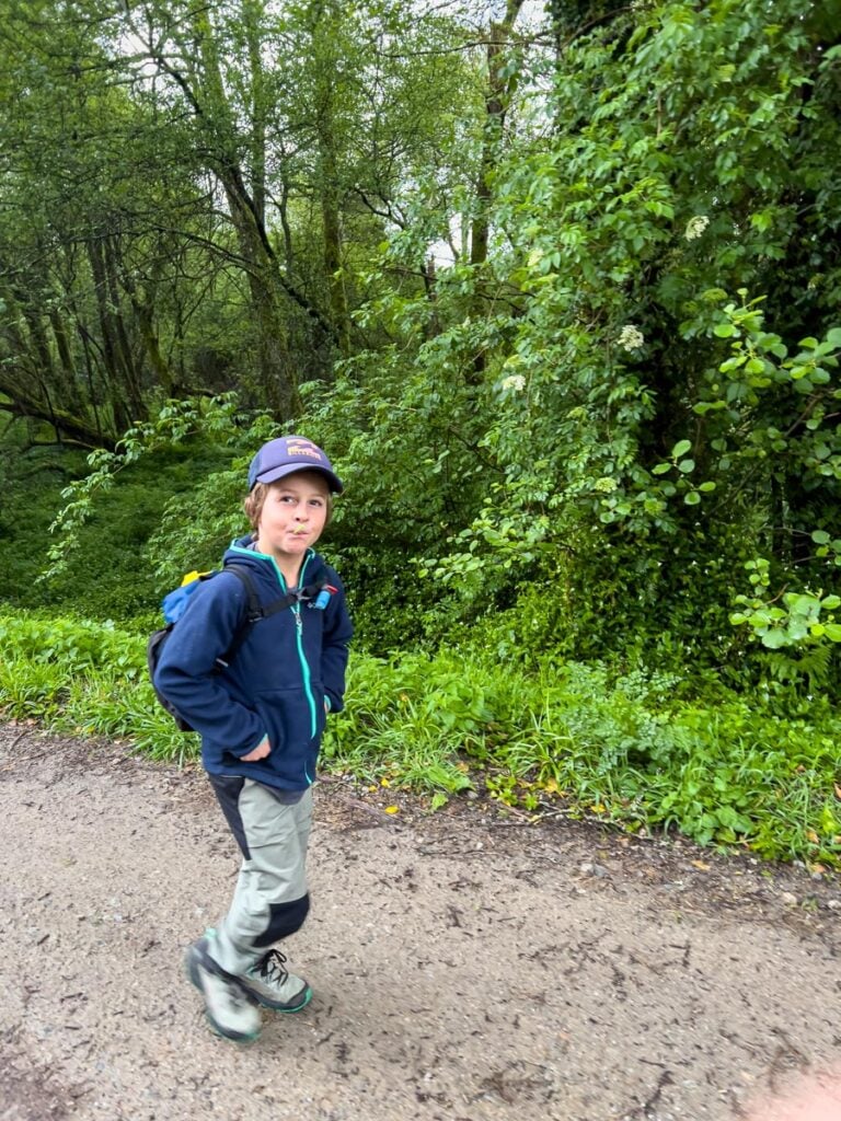 An 8-year old sucks on a lollipop as he hikes the Portuguese Coastal Camino Trail with his family.