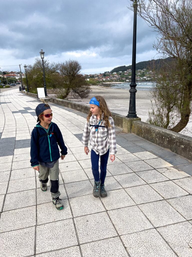 The Family Can TRavel kids walk on a beach boardwalk during their self-guided, family-friendly Portuguese Coastal Camino tour.