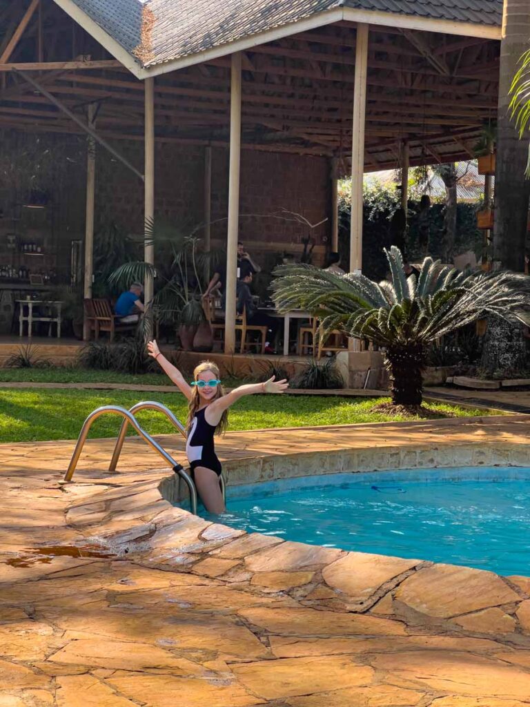 an 11-year old girl enjoys an outdoor swimming pool at a safari lodge in Tanzania.