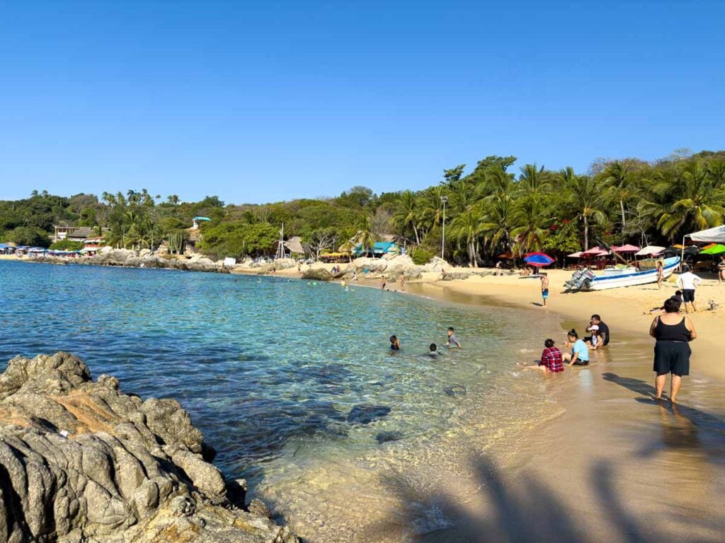 the clear turquoise waters of Playa Manzanillo in Puerto Escondido, Mexico.
