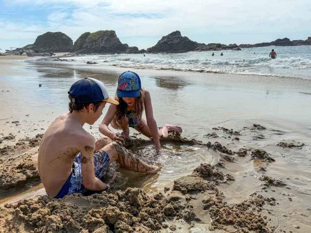Two kids play in the sand at Playa San Agustinillo on the Oaxacan coastline in Mexico.