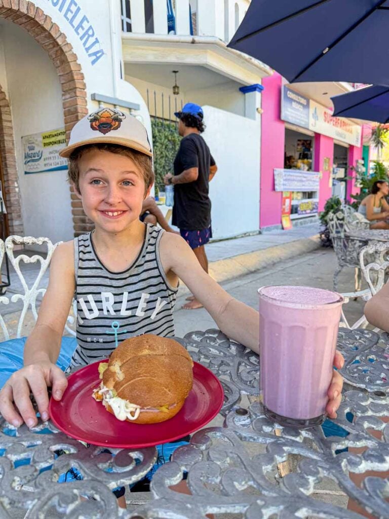 a 9-year old boy enjoys lunch at a family-friendly restaurant in the Rinconada district of Puerto Escondido.