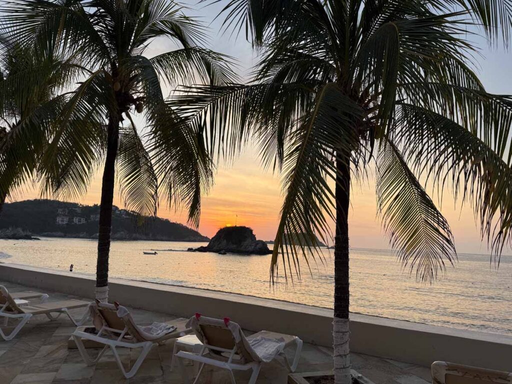 Backlit palm trees at sunrise at the Barcelo Huatulco all-inclusive resort.