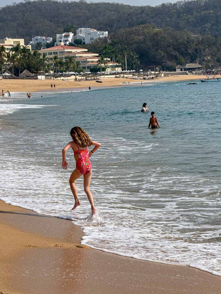 an 11-year old girl plays in the surf on Tangolunda Bay, Mexico.