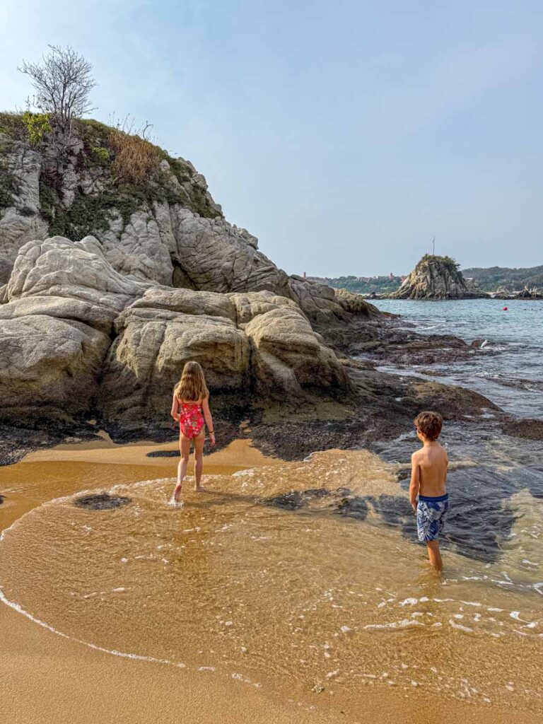 Two kids have fun on the golden sand on Tangolunda Bay during a stay at the Barcelo Huatulco.