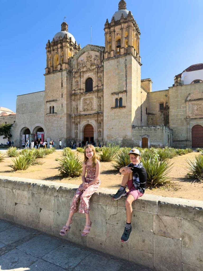 The FamilyCanTravel.com kids relax in the plaza outside the Catedral Metropolitana de Oaxaca Nuestra Señora de la Asunción on a family trip to Oaxaca, Mexico.