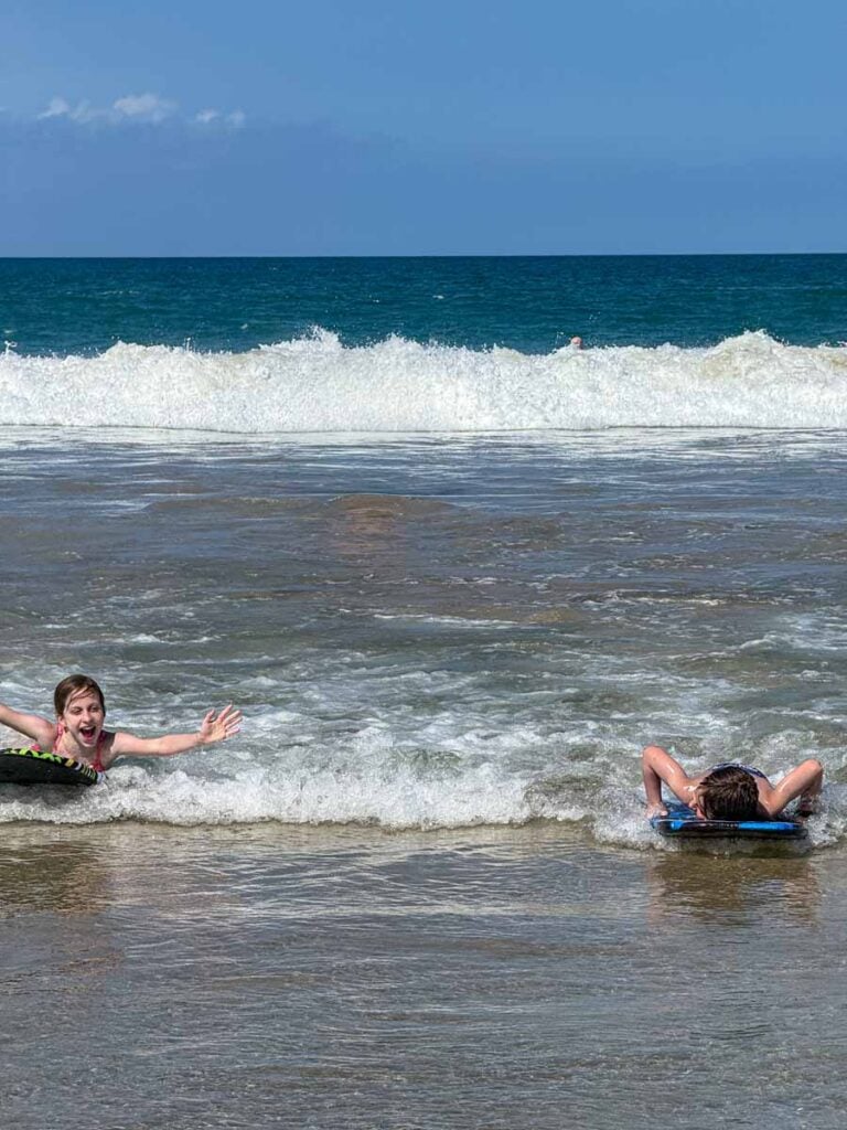 Two kids having a ball boogie boarding at Hāpuna Beach on the Big Island of Hawaii.