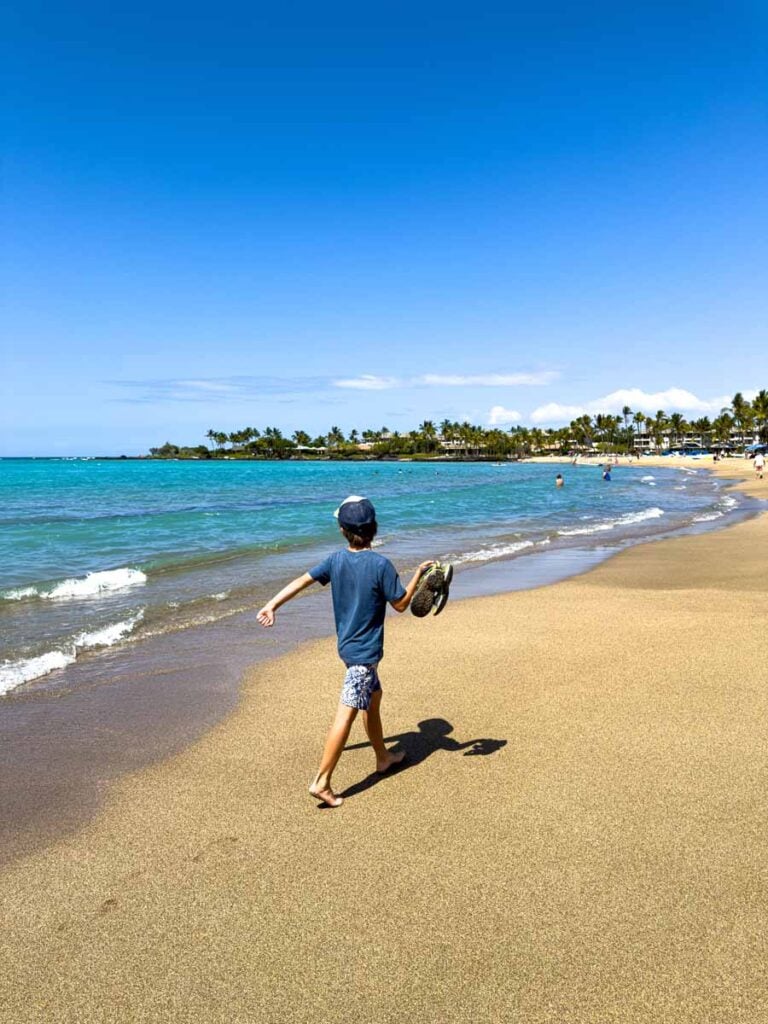 A 9-year old on a family trip to Hawaii walks on 'Anaehoʻomalu Beach - one of the most family friendly beaches on the Big Island.