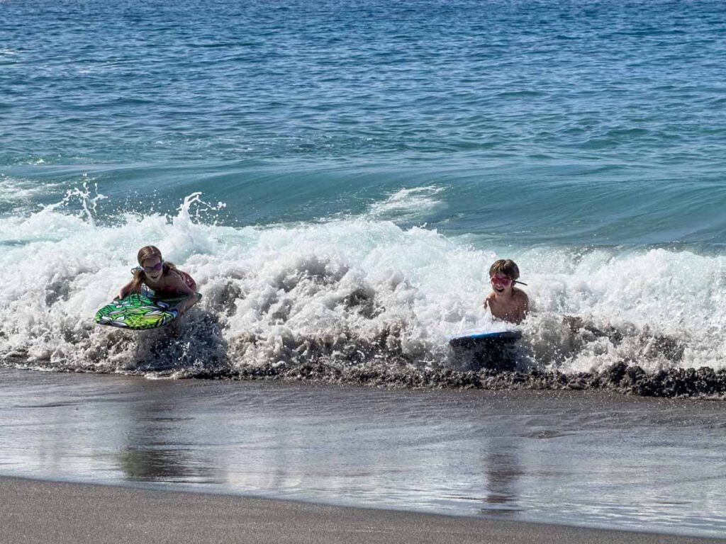 The Brewer kids, from the Family Can Travel blog, enjoy boogie boarding at Ho’okena Beach Park on the Big Island.