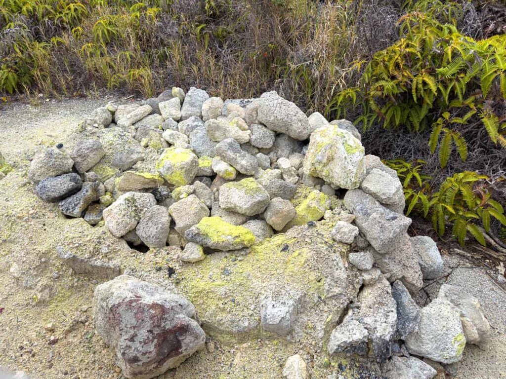 Rocks with yellow sulphur deposits on them line the Sulphur Banks Trail at Hawaii Volcanoes National Park.