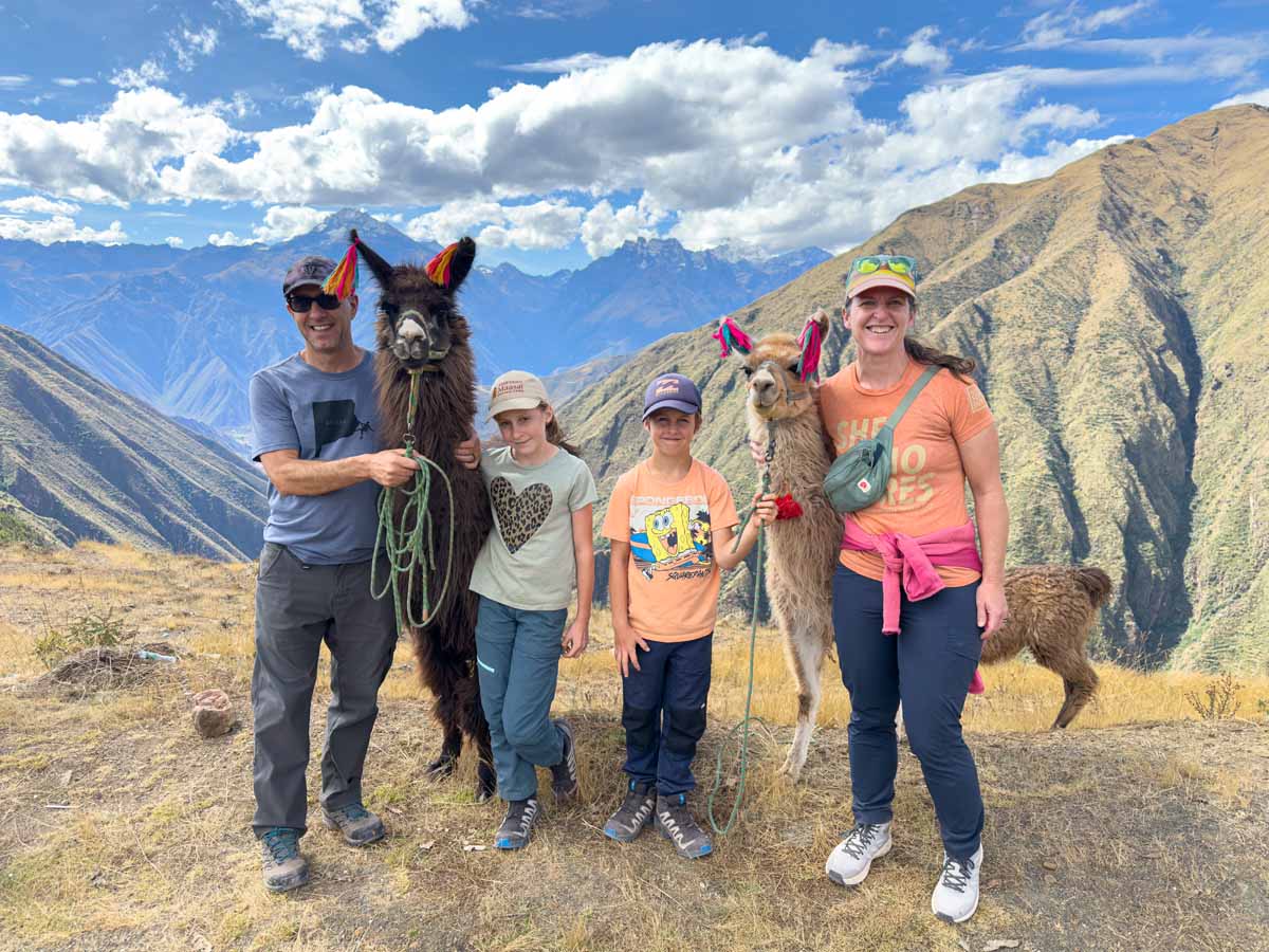 Dan and Celine Brewer, owners of FamilyCanTravel.com, enjoy hiking with llamas while visiting Cusco with their kids.