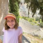Family-Friendly Athens Day Trips - Delphi an 11-year old girl is all smiles during a visit to Delphi on a family trip to Greece.