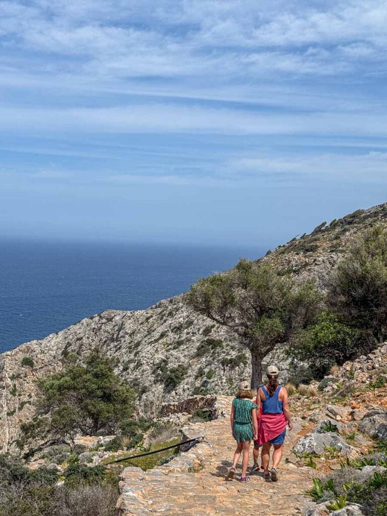 Celine Brewer and her daughter enjoy epic views of the Aegean Sea while on the Cave of Agios Ioannis the Hermit and the Katholiko Fjord Hike.