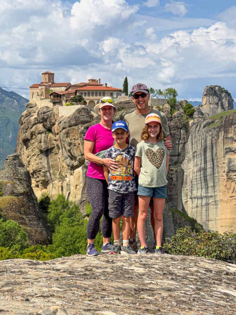 The Brewer family, from the FamilyCanTravel.com, stand in front of the Holy Trinity Monastery while on a family hike around Meteora, Greece.