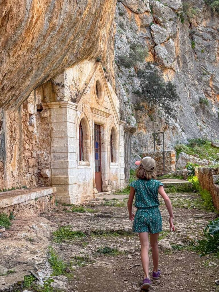 An 11-year old girl hikes past the Katholiko Monastery on a family hike in Crete, Greece.