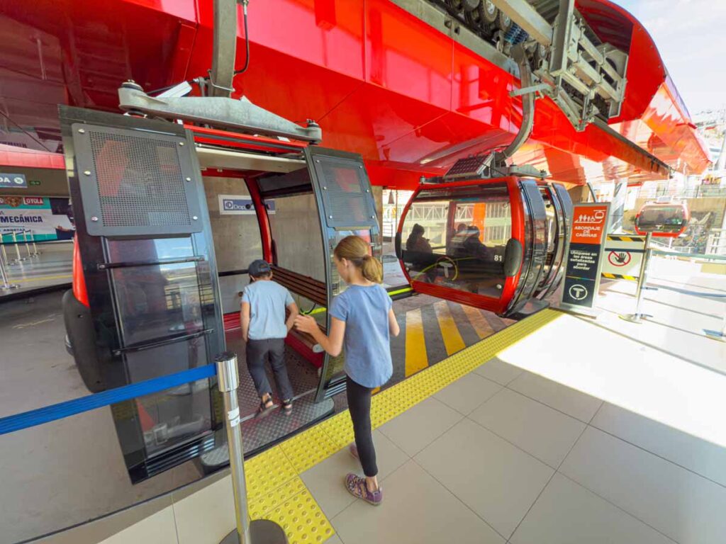 The kids from the FamilyCanTravel.com blog board a cable car on the red line at the Estacion Central in La Paz, Bolivia.