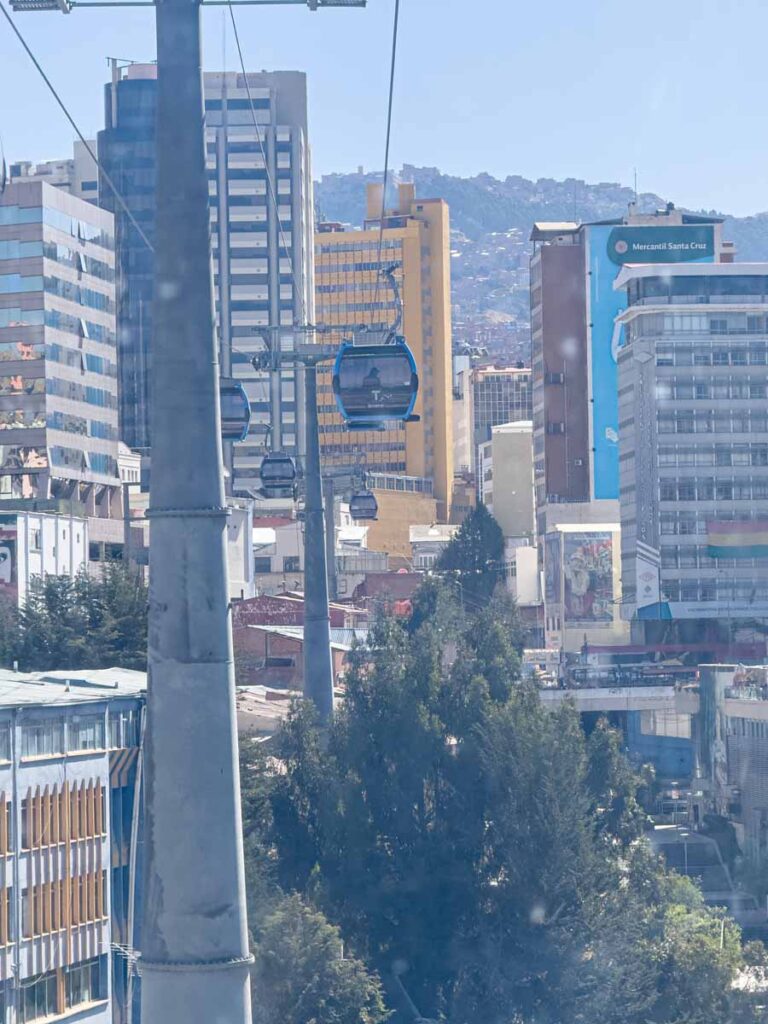 Cable cars on the Sky Blue line run through high-rise buildings in La Paz, Bolivia.