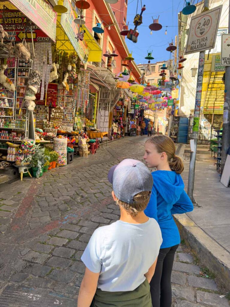 The Brewer kids, from the Family Can Travel blog, enjoy shopping at the Witches Market - one of the best things to do with kids in La Paz, Bolivia.