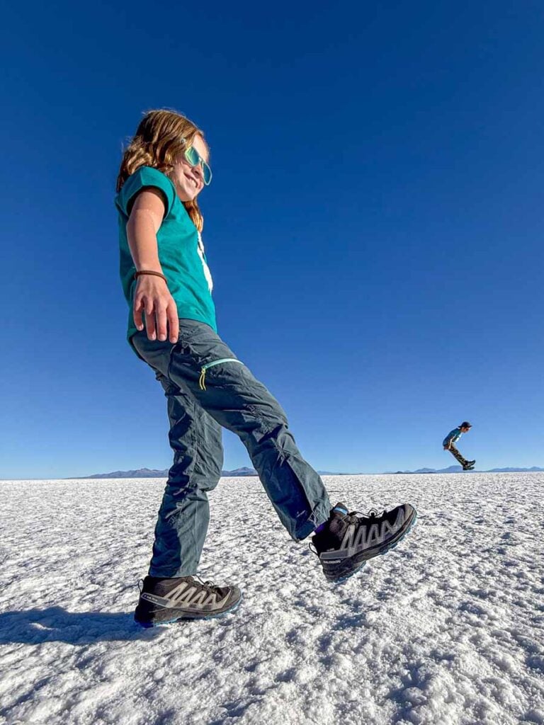 an 11-year old girl on a family holiday to Bolivia, appears to be drop-kicking her little brother in a forced perspective picture at the Uyuni Salt Flats in Bolivia.
