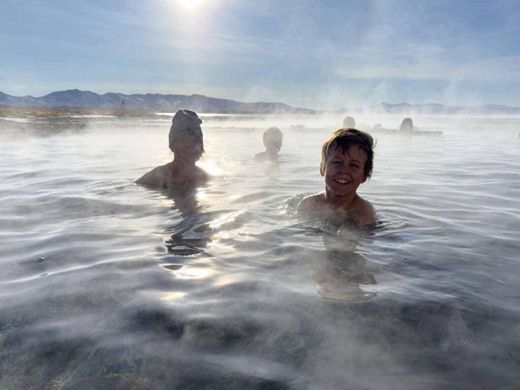 Celine Brewer, owner of FamilyCanTravel.com, and her son enjoy an early morning soak in the Agua Termales de Polques while on a 3-day tour of the Uyuni Salt Flats.