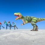 Uyuni Salt Flats with kids - forced perspective photos - Green T-rex Dan and Celine Brewer, owners of FamilyCanTravel.com, pose for a fun forced perspective photo with their kids and a giant T-Rex in the Uyuni Salt Flats, Bolivia.